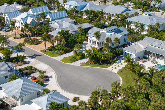 Aerial view of millionaire neighborhood with large houses and lush landscaping in a wealthy residential area.
