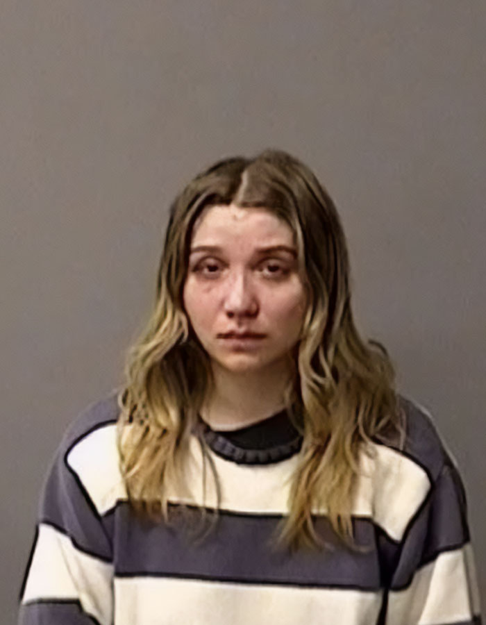 Young woman in a striped sweater with long hair, involved in an incident with her daughter and a canal.