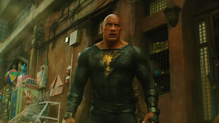 Dwayne Johnson showcasing his impressive transformation in a dark superhero suit ahead of new biopic filming.