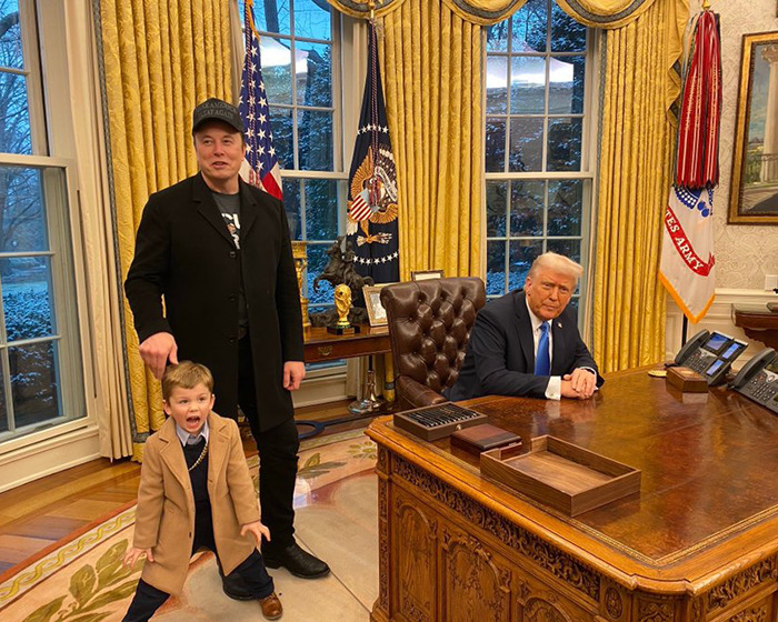 Man in a hat with child, standing in a decorated office next to seated figure. SEO keywords: Elon Musk stepping down DOGE.