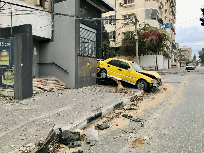 Yellow car crashed into building steps, highlighting an adult's memorable tantrum aftermath.