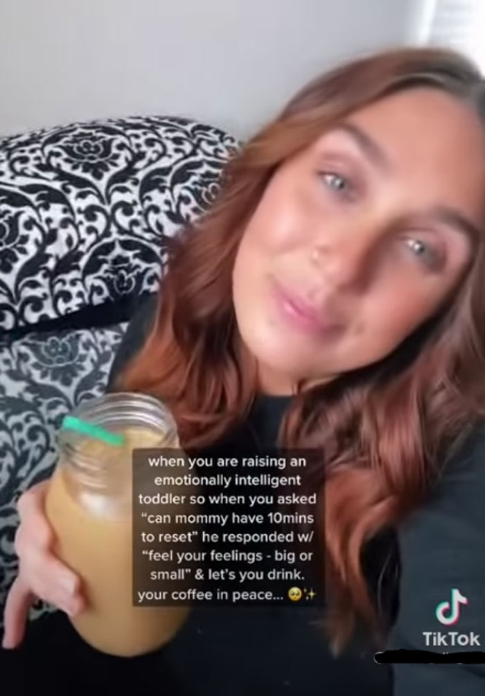 Woman holding iced coffee, with text about managing an emotionally intelligent toddler; cringe moment captured on TikTok.