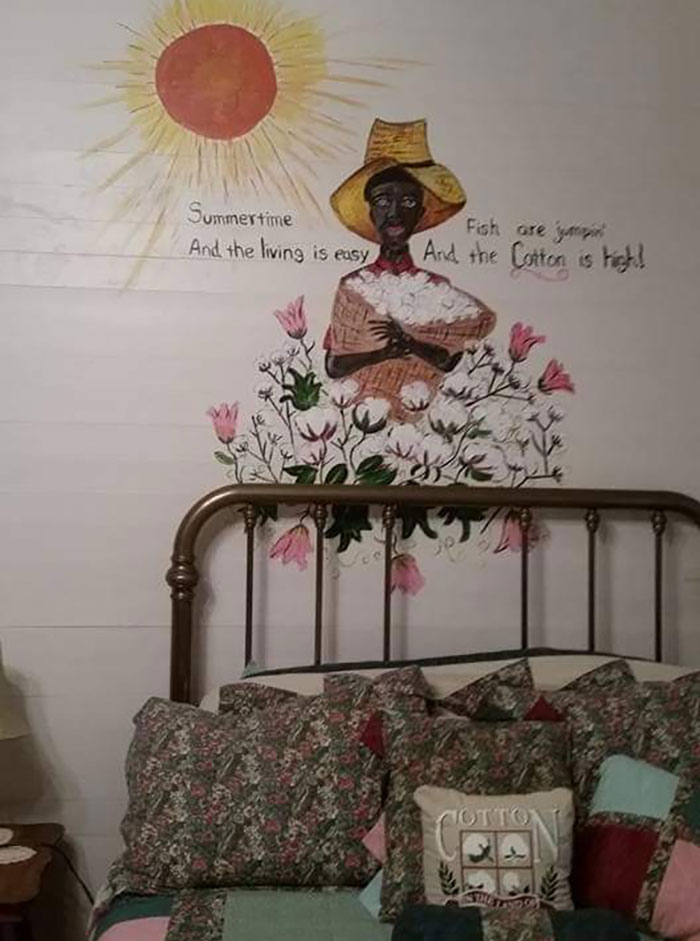 Mural of a person holding cotton under text about summertime, sun above, over a bed with floral bedding. Cringe behavior art.
