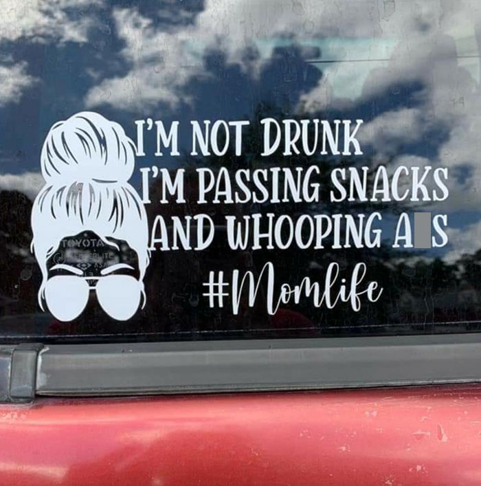 Calcomanía de coche con mensaje gracioso que provoca vergüenza ajena, "#Momlife", sobre fondo de cielo nublado.