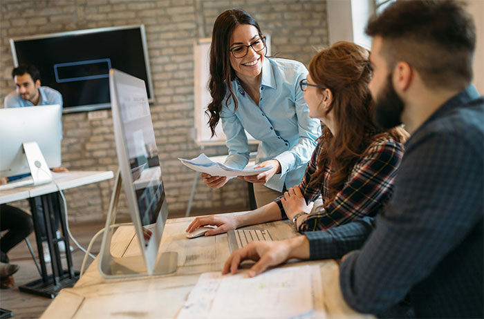Office discussion among colleagues, sharing unknown employer insights in a modern workspace.