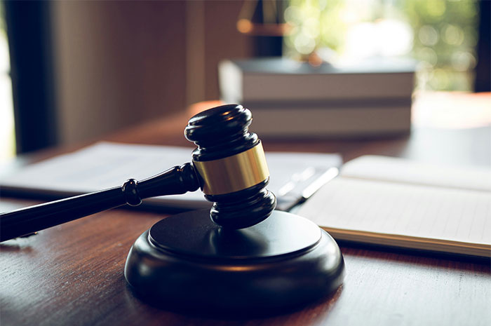 Gavel on a wooden desk with blurred legal books, symbolizing what employers don’t want employees to know.