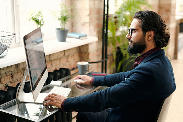 Man working at desk with computer, focusing on work-related secrets employers might not want revealed.