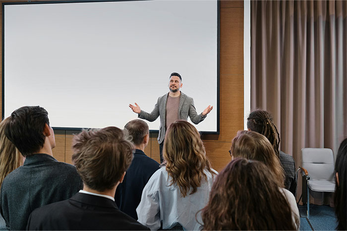 Person speaking to employees in a conference room setting, sharing insights employers might keep undisclosed.