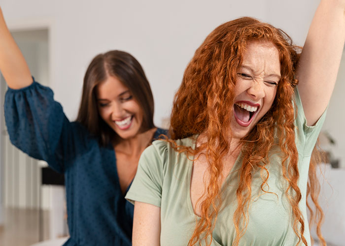 Two women excitedly smiling, embodying distinct European travel reactions.