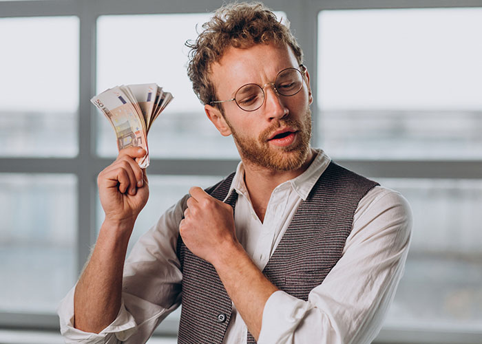 Man in glasses holding euros, illustrating European perceptions of Americans traveling.