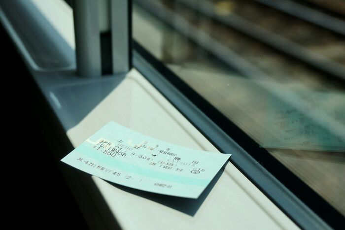 Train ticket resting on a window sill, symbolizing loopholes in travel systems.