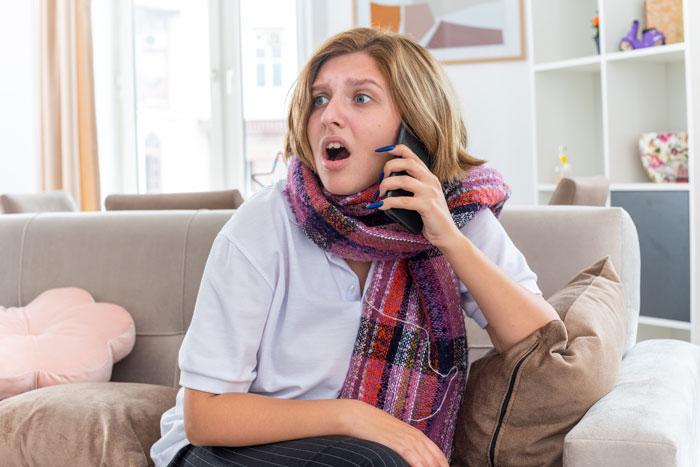 Woman on phone looking shocked in living room, hacking email topic. Woman on phone looking shocked in living room, hacking email topic.