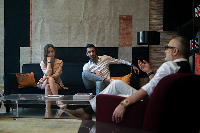 A woman and two men in a tense discussion, with the woman looking upset, related to wedding step MIL conflict.