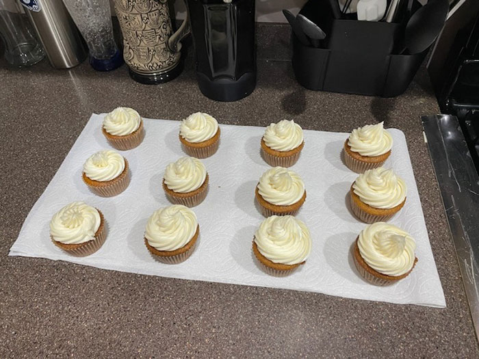 Cupcakes with white frosting on a kitchen counter, illustrating a family gathering before a husband confronts over treatment of pregnant wife.