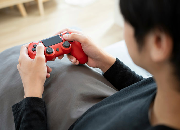Person holding a red game controller, possibly illustrating a moment reflecting on friendships.