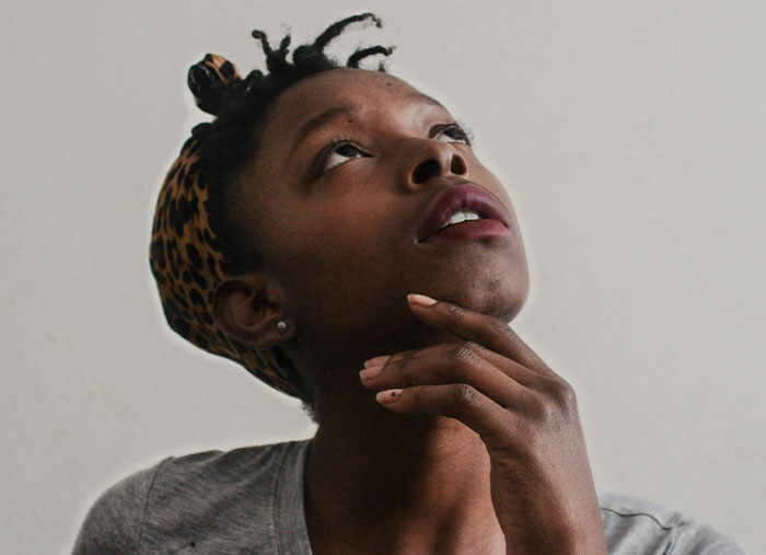 Woman in thought, hand on chin, contemplating the ending of a friendship.