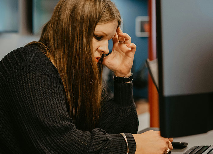 Woman in deep thought at a computer, reflecting on ending friendships.