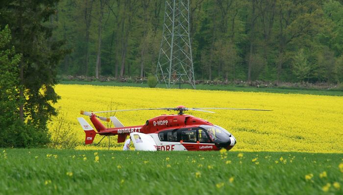 Rescue helicopter in a bright yellow field, a scene related to EMTs and first responders on duty.