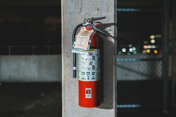 Fire extinguisher in a garage, highlighting safety measures for EMTs and first responders against mistakes.