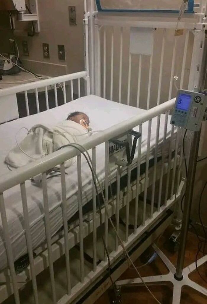 Infant in a hospital crib with medical equipment, illustrating a forbidden story from around the world.