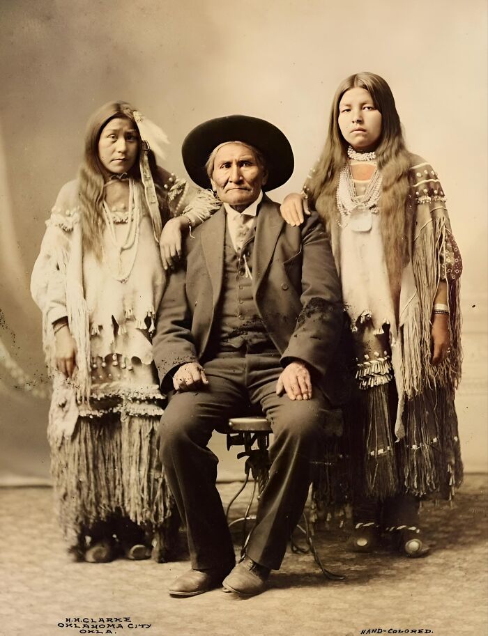 Elderly man in traditional attire with two young women, showcasing forbidden stories through cultural heritage.