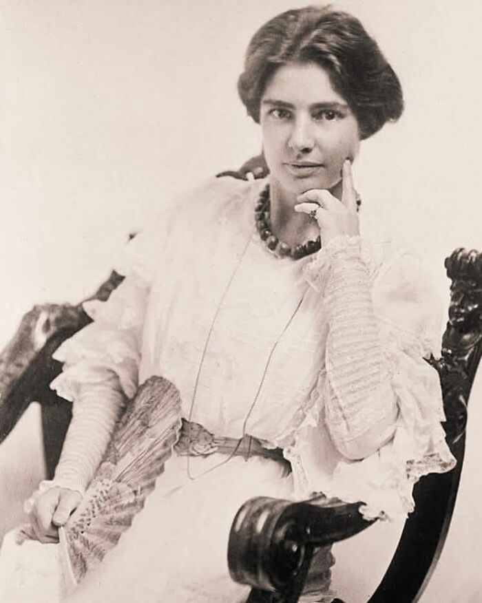A woman in a vintage dress sits thoughtfully in an antique chair, symbolizing forbidden stories from around the world.