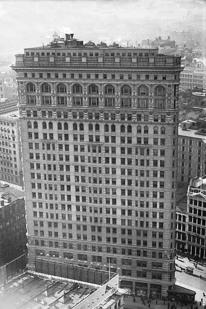 Historic skyscraper in a bustling cityscape, showcasing architectural details.