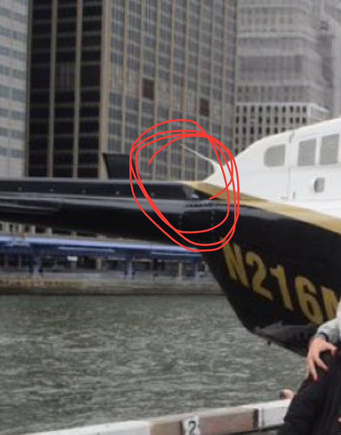 Helicopter detail with red circle before crash over water, suggesting possible cause.