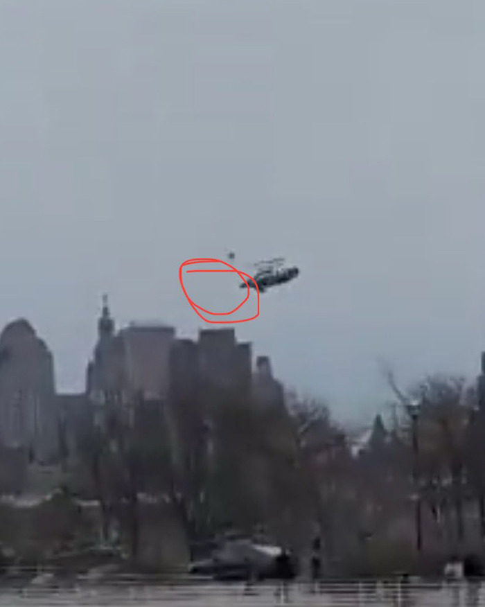 Helicopter in mid-flight before crash, circled area highlighted, potential clue to incident cause.