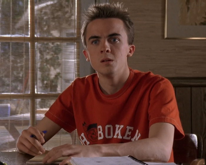 Frankie Muniz as Malcolm, wearing an orange shirt, in a scene from 'Malcolm In The Middle' reunion post.