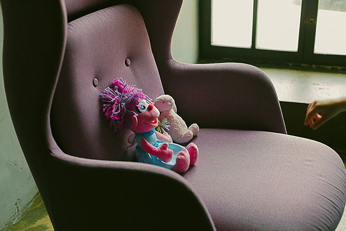 Plush toys on an empty chair, symbolizing babysitting disappearance.