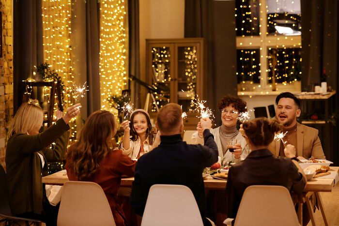 Group of friends celebrating at a festively decorated table with sparklers, related to concerns about a financial situation.