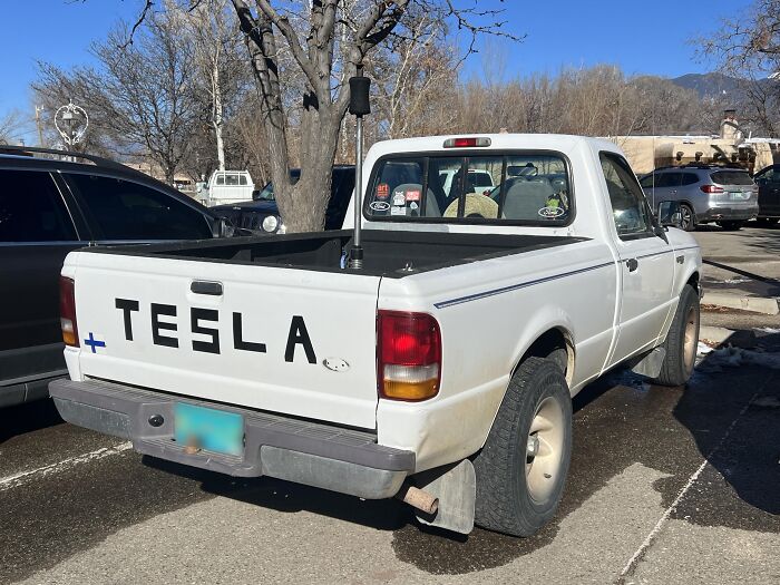Pickup truck with 'Tesla' label on the tailgate, showcasing a confidently incorrect modification.