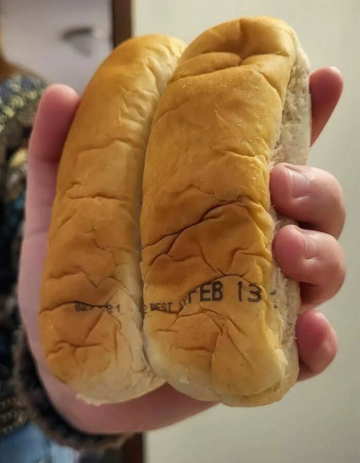 Confidently incorrect: Hot dog buns stamped with a February expiration date held in a hand.