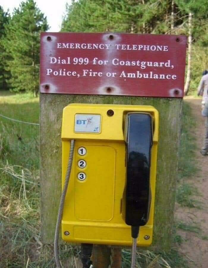 Emergency phone in forest with a sign to dial 999 for coastguard, police, fire, or ambulance, showcasing a confident fail.