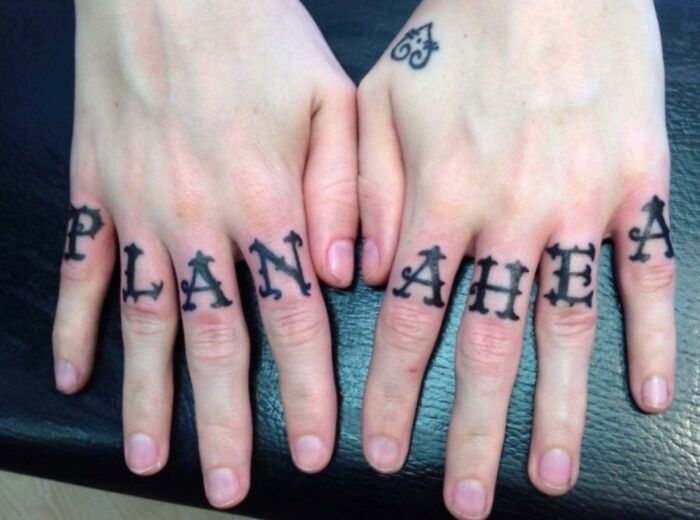 Confidently incorrect tattoo reads "PLAN AHEA" with missing letter, illustrating a humorous fail.