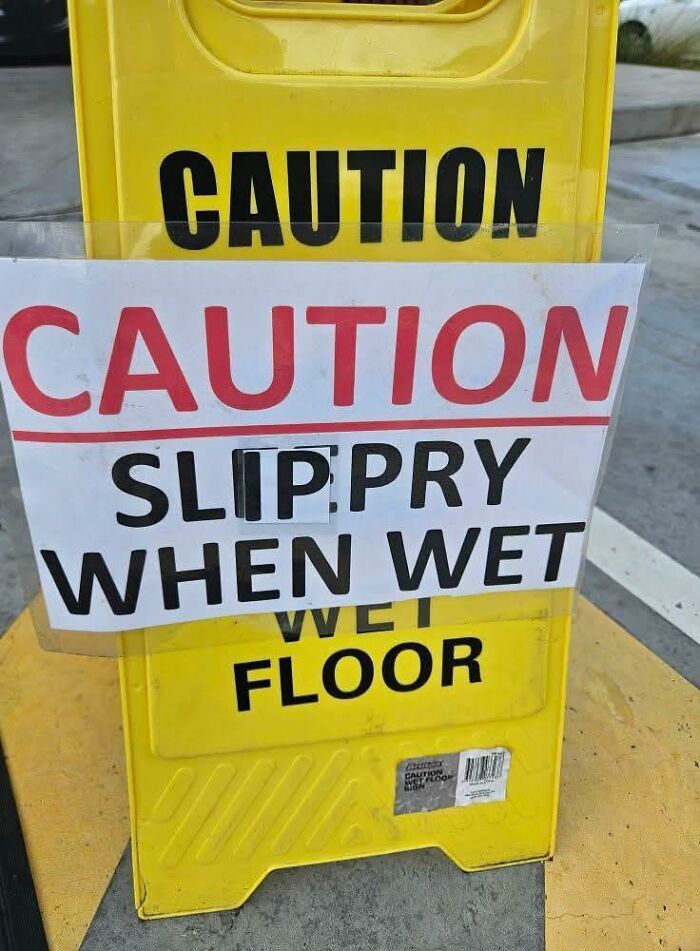 Yellow caution sign with a misspelled warning, "Slippry When Wet," showcasing a confidently incorrect fail.