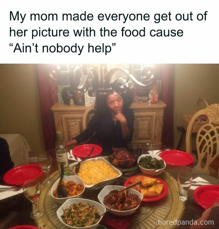 Woman sitting at a dining table with an array of dishes, capturing a funny moment with food.
