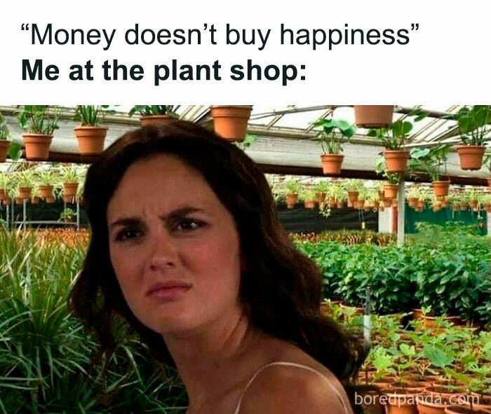Confused woman in a plant shop, surrounded by potted plants, capturing a humorous moment for plant owners.