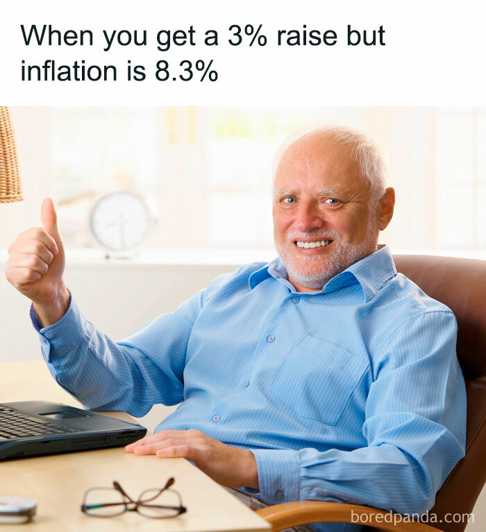 Smiling man in blue shirt, giving a thumbs up at a desk with a laptop, showcasing a funny relatable work meme.