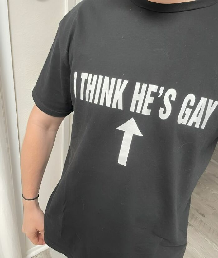 Camiseta divertida y ridícula negra con texto en inglés y flecha que señala al usuario, ejemplo de camisetas para usar en público.