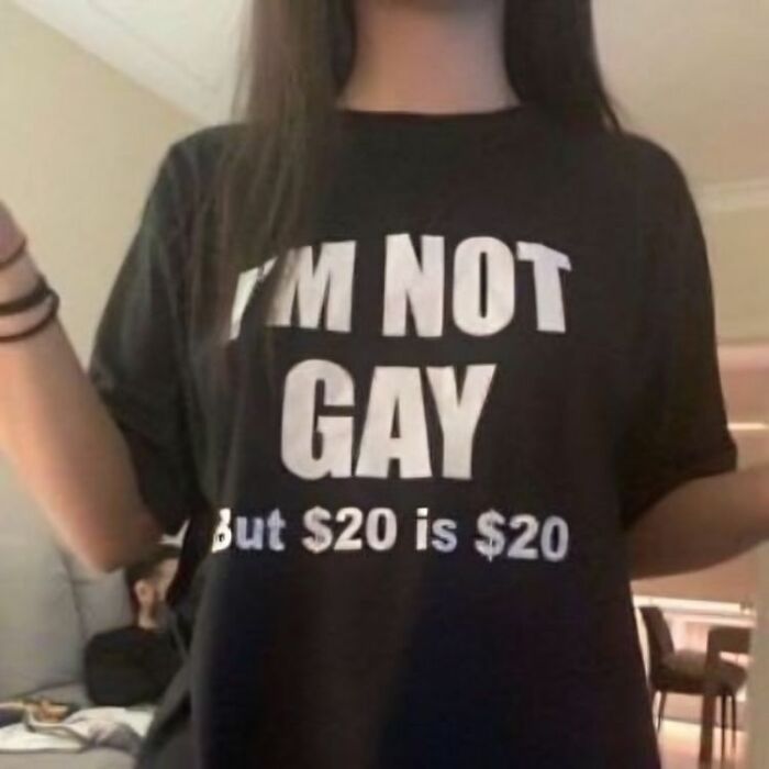 Persona con camiseta divertida y ridícula con texto en inglés, mostrando moda informal y humor en prendas públicas.