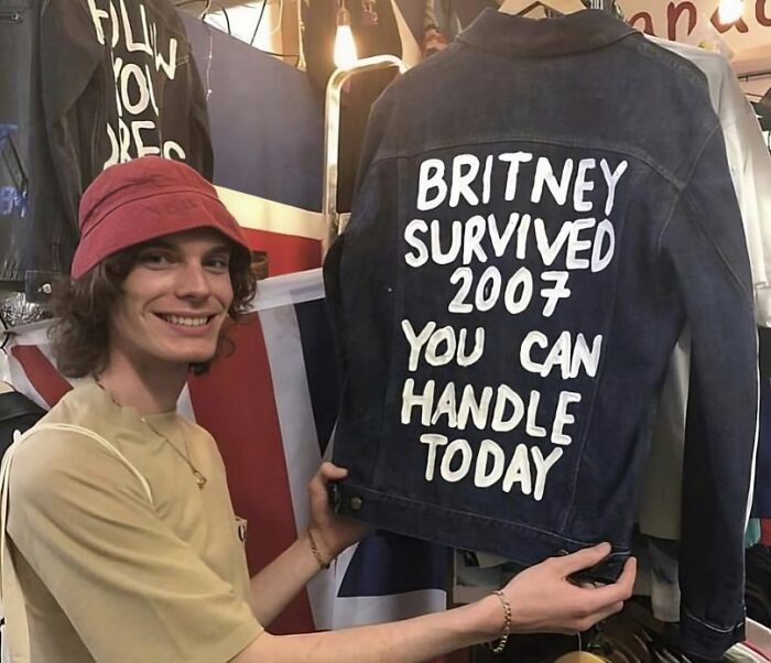 Joven sostiene una chaqueta con mensaje divertido, ejemplo de camisetas tan divertidas como ridículas para uso público.