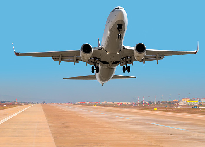 Airplane taking off from runway under clear blue sky, image related to frustrated passengers and airline delays.