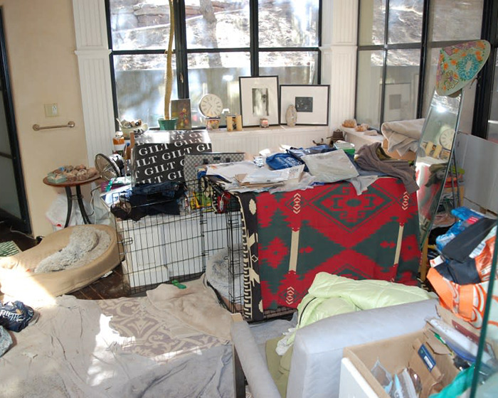 Messy room with colorful blanket and framed art, related to Gene Hackman's notes found.