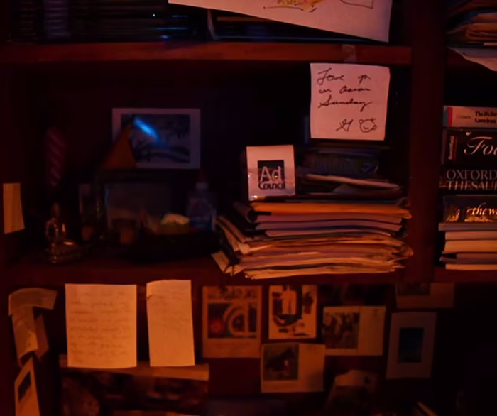 Handwritten notes to Betsy by Gene Hackman on a cluttered desk, surrounded by books and papers.