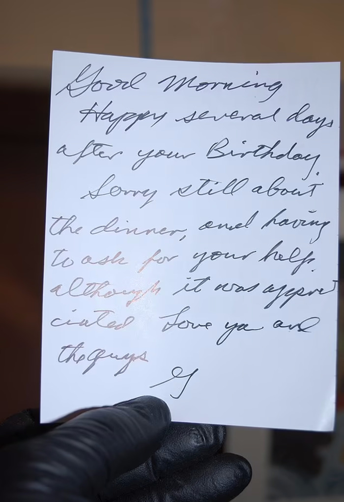 Handwritten note from Gene Hackman to wife Betsy, held by a person wearing black gloves.