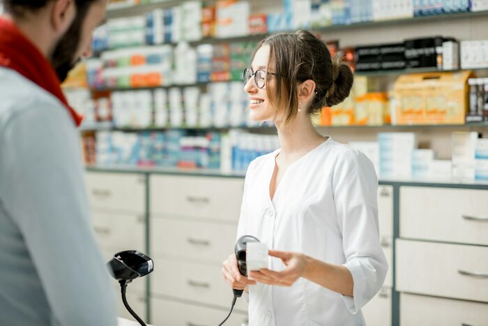 Pharmacist in a white coat assists customer, symbolizing loopholes in pharmacy interactions.