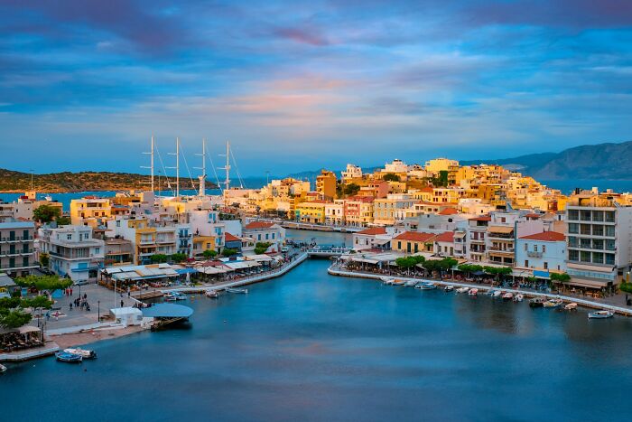 Colorful coastal town with luxury yachts, exemplifying the influence of the filthy rich on island life.