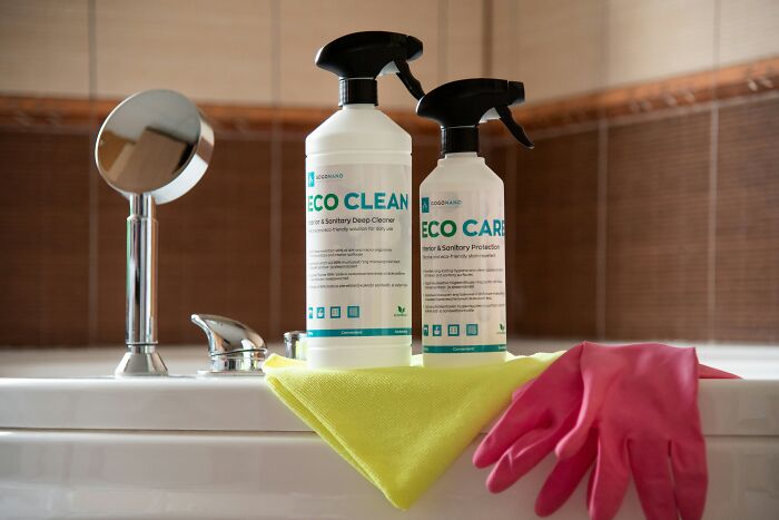Eco cleaning products and pink gloves on a bathroom sink, highlighting their seemingly harmless yet potentially dangerous nature.